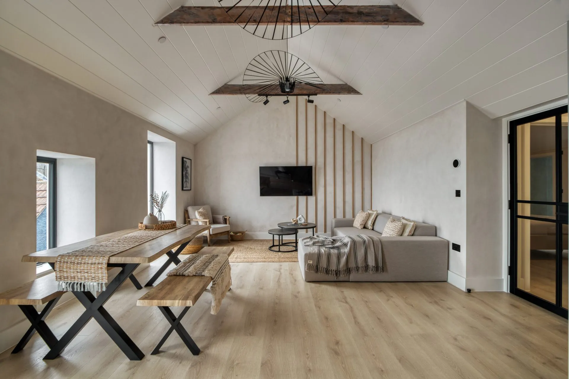 Open plan living and dining in a Gower holiday apartment with lime washed plaster and oak floor